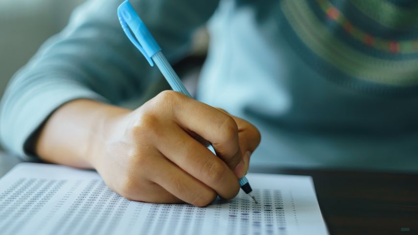 Law student write on exam paper